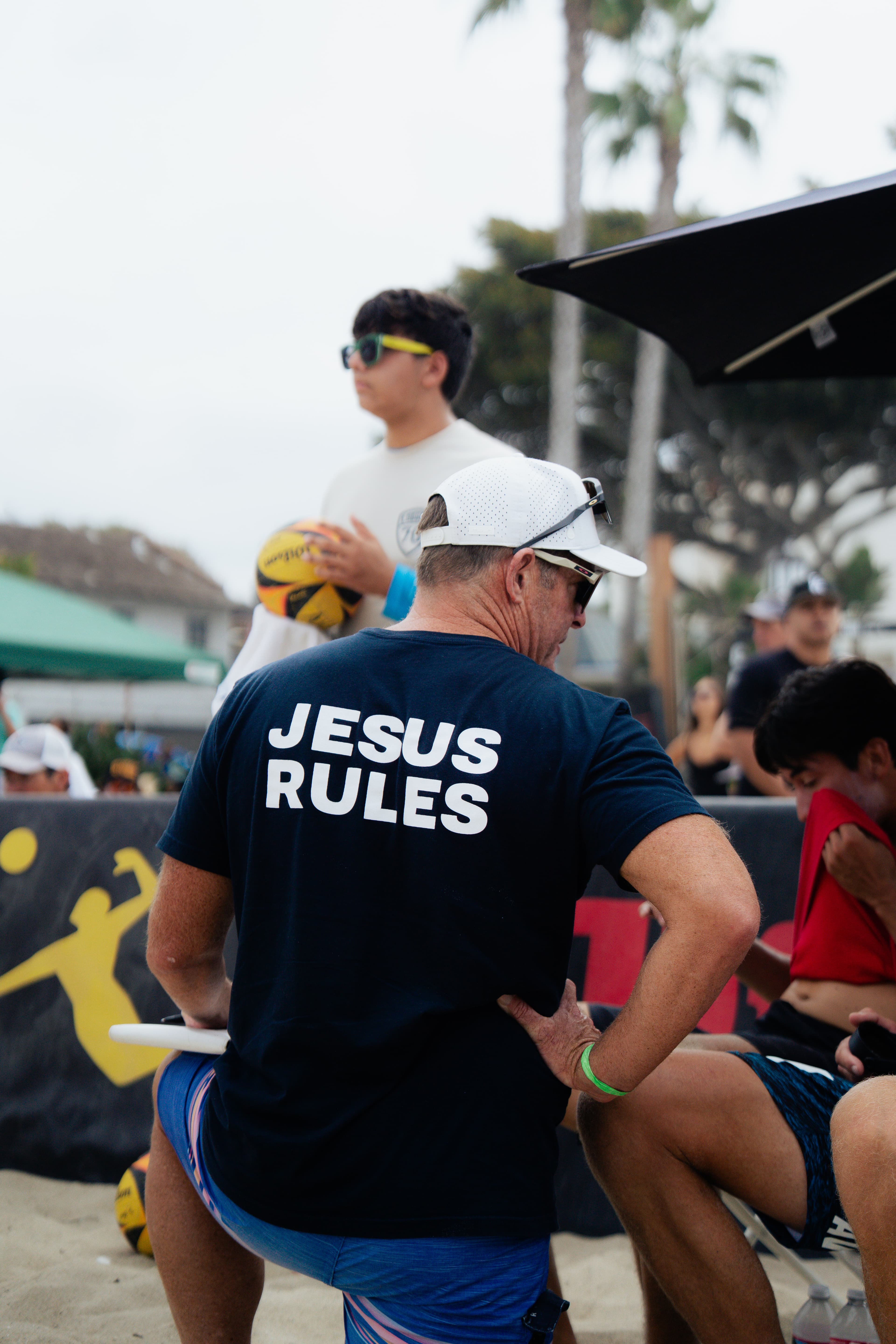 Michael courtside in navy Jesus Rules tee
