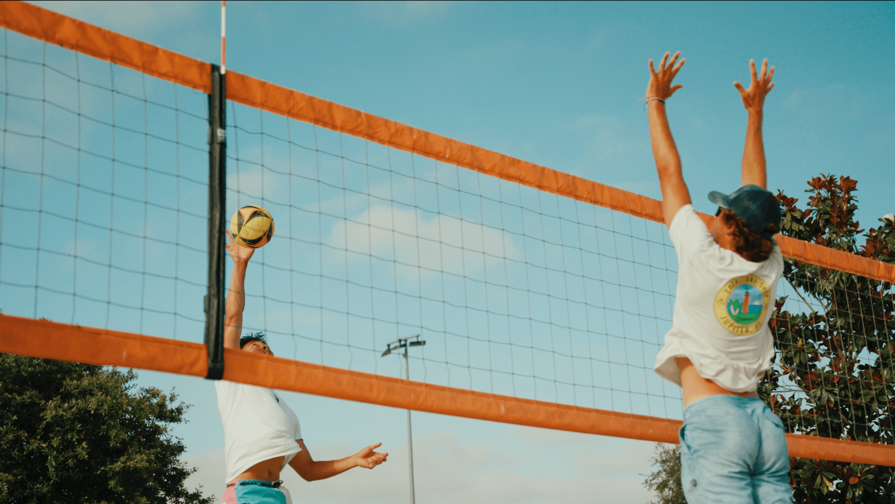 Players at the net during beach volleyball match